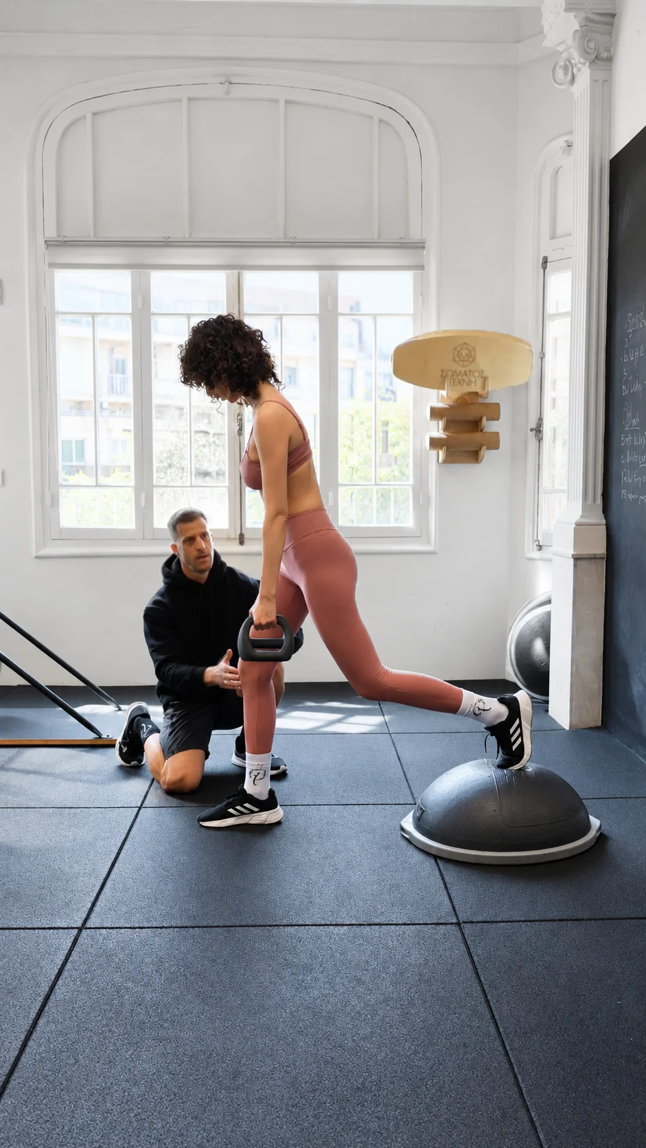 Προσωπικός γυμναστής καθοδηγεί άσκηση με kettlebell και BOSU στο Σώματος Τέχνη